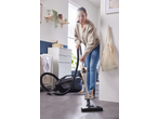 Mulher a aspirar com um aspirador com filtro de água Silvercrest® numa divisão moderna.