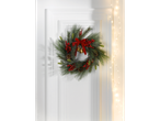 LIVARNO home Christmas Wreath with red berries, pinecones, and bells on a white door.
