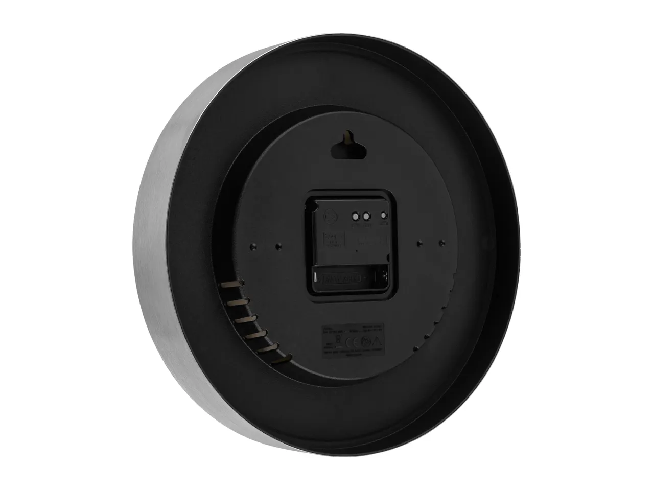 Back of a round wall clock with a brushed metal frame, showing the battery compartment and settings.