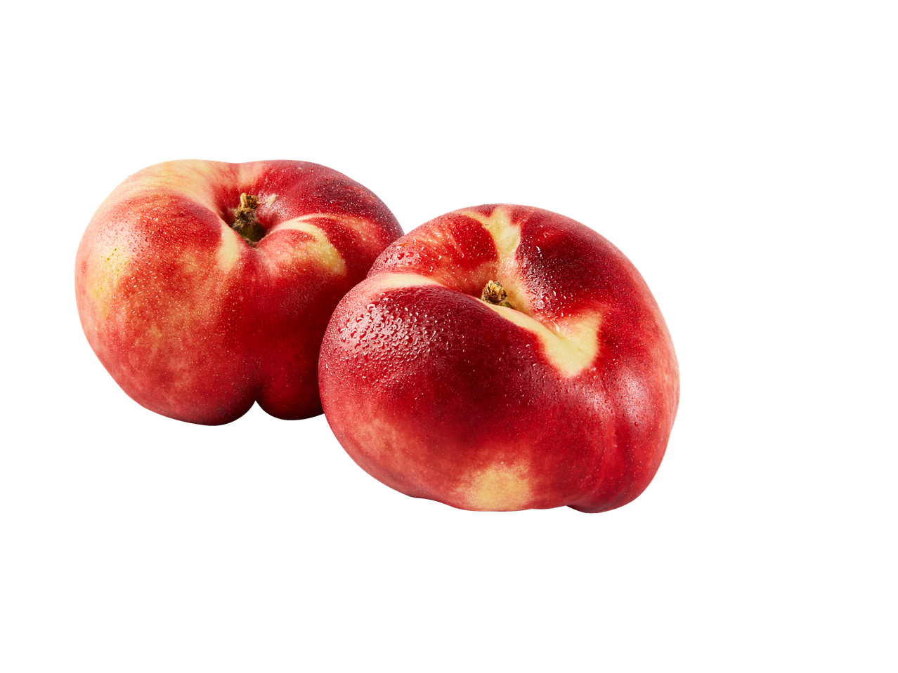 Twee verse, rijpe platte nectarines met waterdruppels op een zwarte achtergrond.