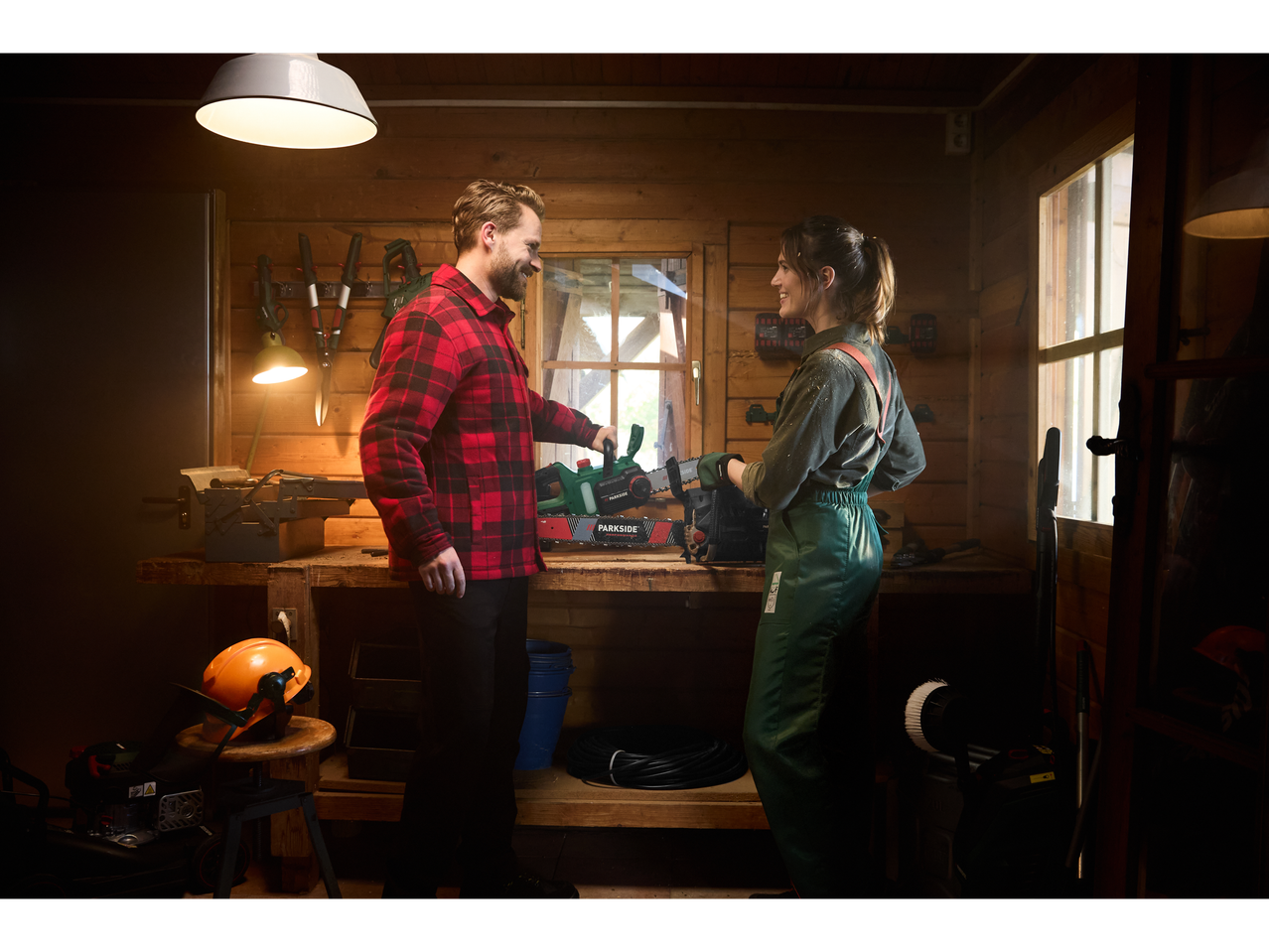 Man and woman in a workshop with a Parkside chainsaw.