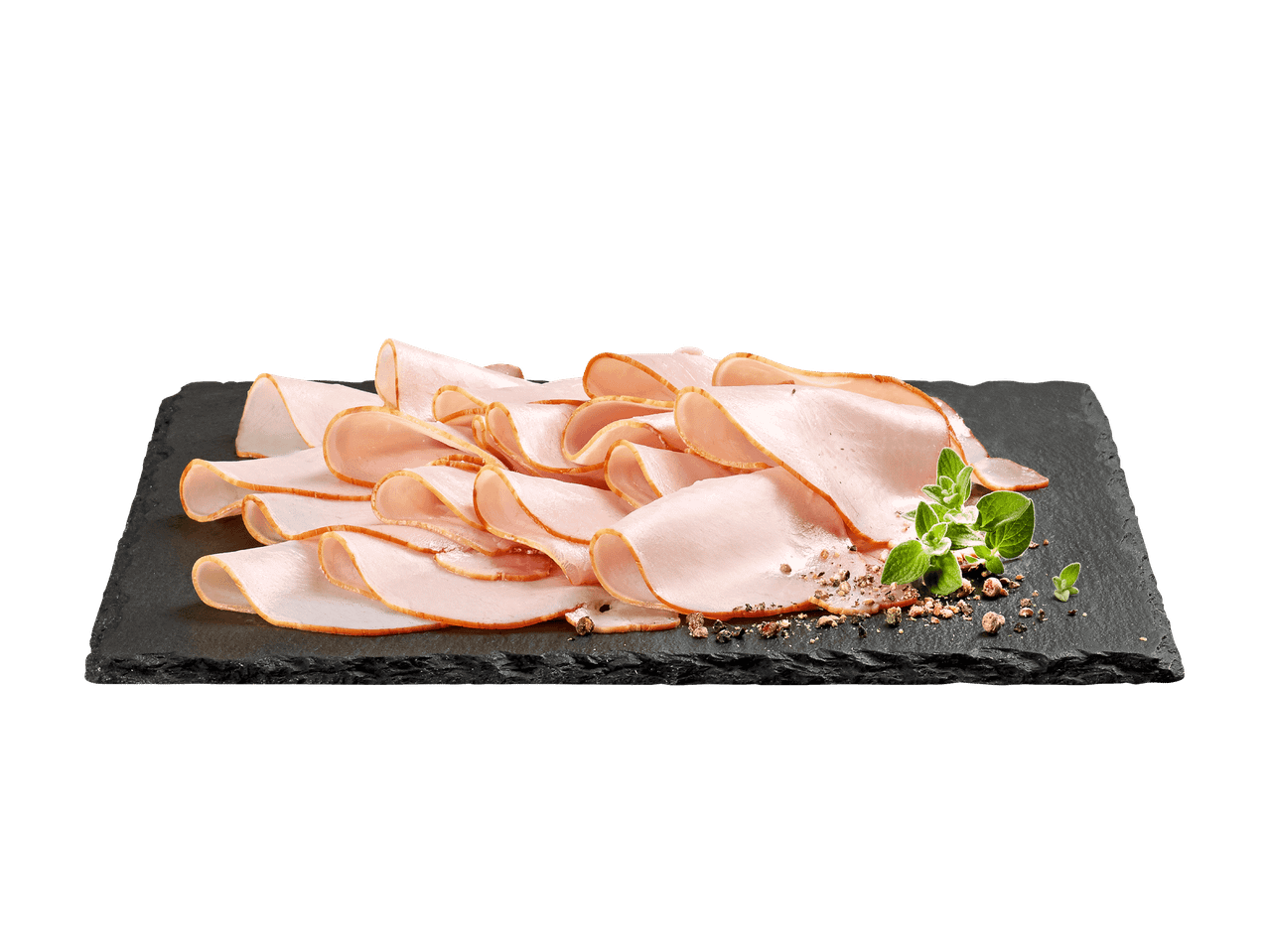 Geschnittener Putenschinken auf einer schwarzen Schieferplatte, garniert mit Kräutern und Pfeffer.