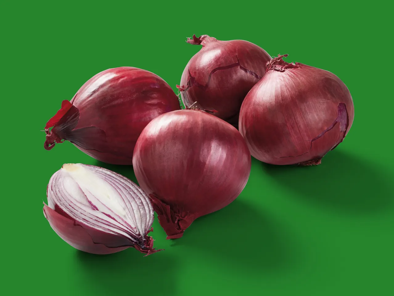 Rote Zwiebeln, eine davon halbiert.