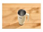 Cream-colored travel mug with a handle on a light wooden table with shadows.