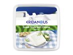 Greek-style soft cheese with herbs on a plate, with bread and a fork, against a Greek island backdrop.