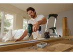 Man using a PARKSIDE® 20V Cordless Impact Driver on a wooden board.