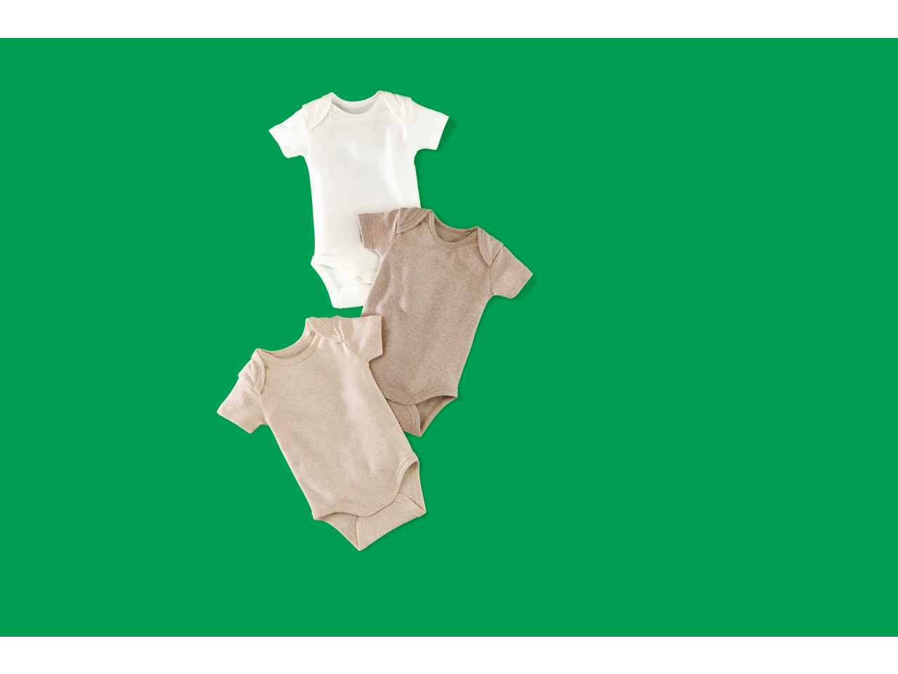 Three neutral-colored baby bodysuits, one white and two beige, arranged diagonally on a green background.