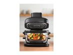 Black air fryer with a clear basket full of colorful vegetables on a wooden counter.