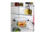 Open fridge with glass containers of salmon, broccoli, pickled vegetables, and jam.