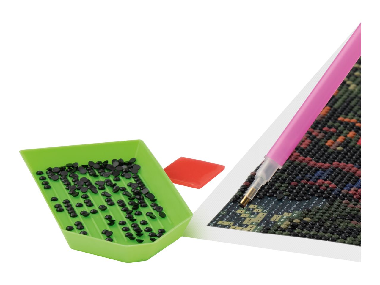 Diamond painting kit with green tray of black diamonds, red wax, and pink pen on a canvas.
