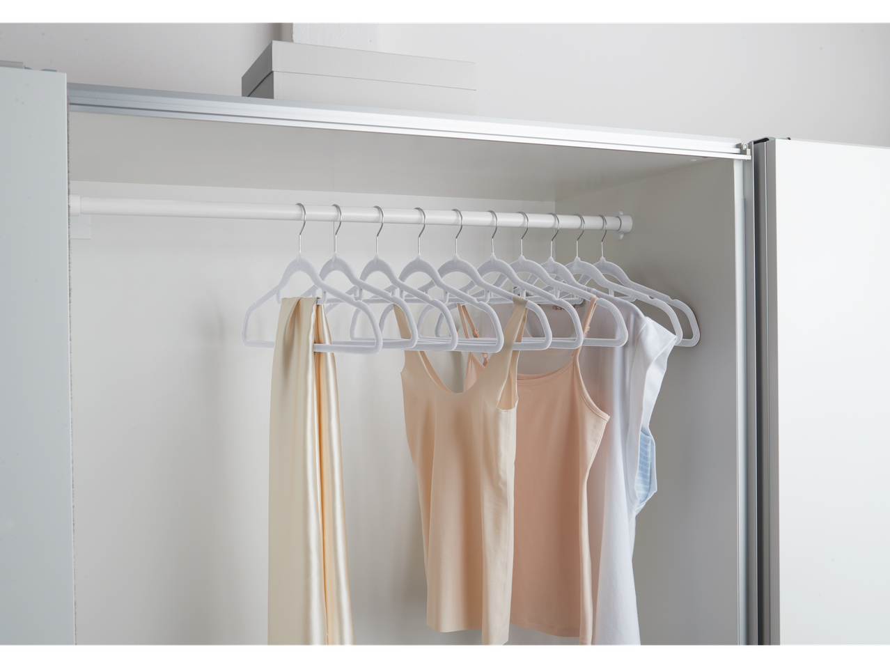 W5 Kleiderbügel in einem Schrank mit Tops und einem Schal.