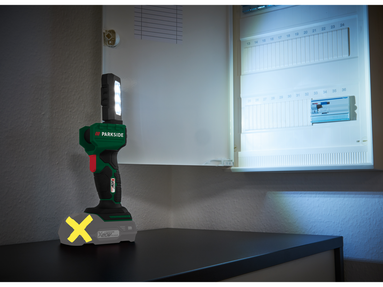 Lanterna portabilă Parkside X20V Team luminează un panou electric.