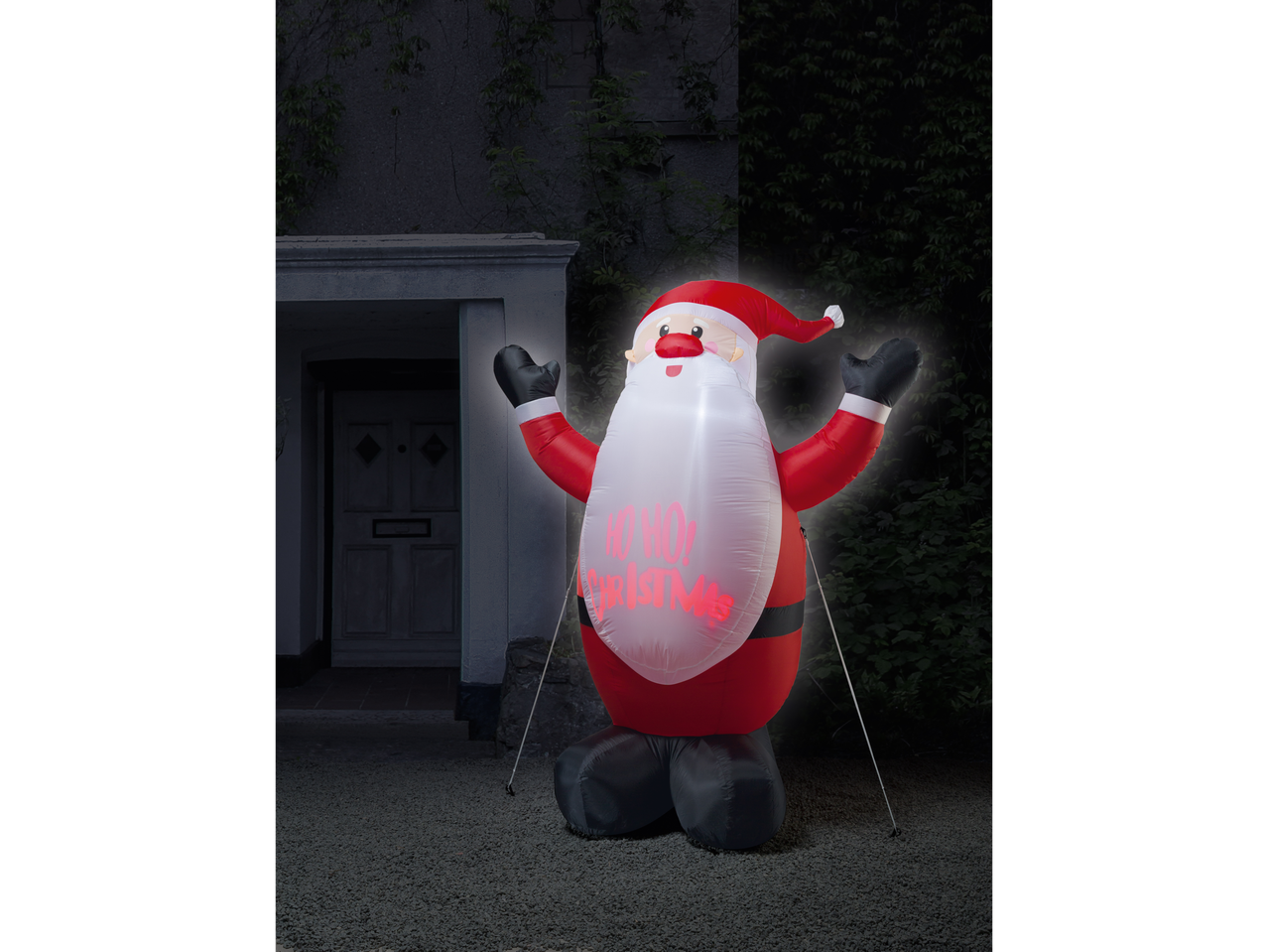 LIVARNO home Inflatable LED Santa Claus figure with 'HO HO HO! CHRISTMAS' text, outdoors at night.