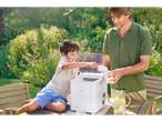 A father and son use a SilverCrest ice maker outdoors.
