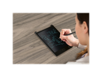 A woman uses a stylus to draw architectural sketches on a black LCD writing tablet.