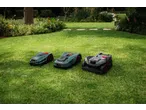 Trei roboți de tuns iarba PARKSIDE PERFORMANCE într-o grădină verde.