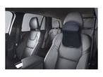 Car interior with black leather seats and a black mesh headrest pillow on the front passenger seat.