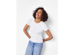 Nasmijana žena u bijeloj Esmara® rebrastoj majici i plavim trapericama.