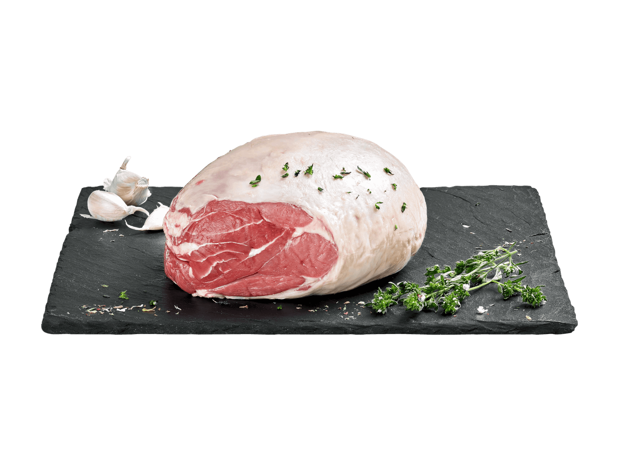 Rohe Lammkeule mit Knoblauch und Thymian auf einem Schieferbrett.