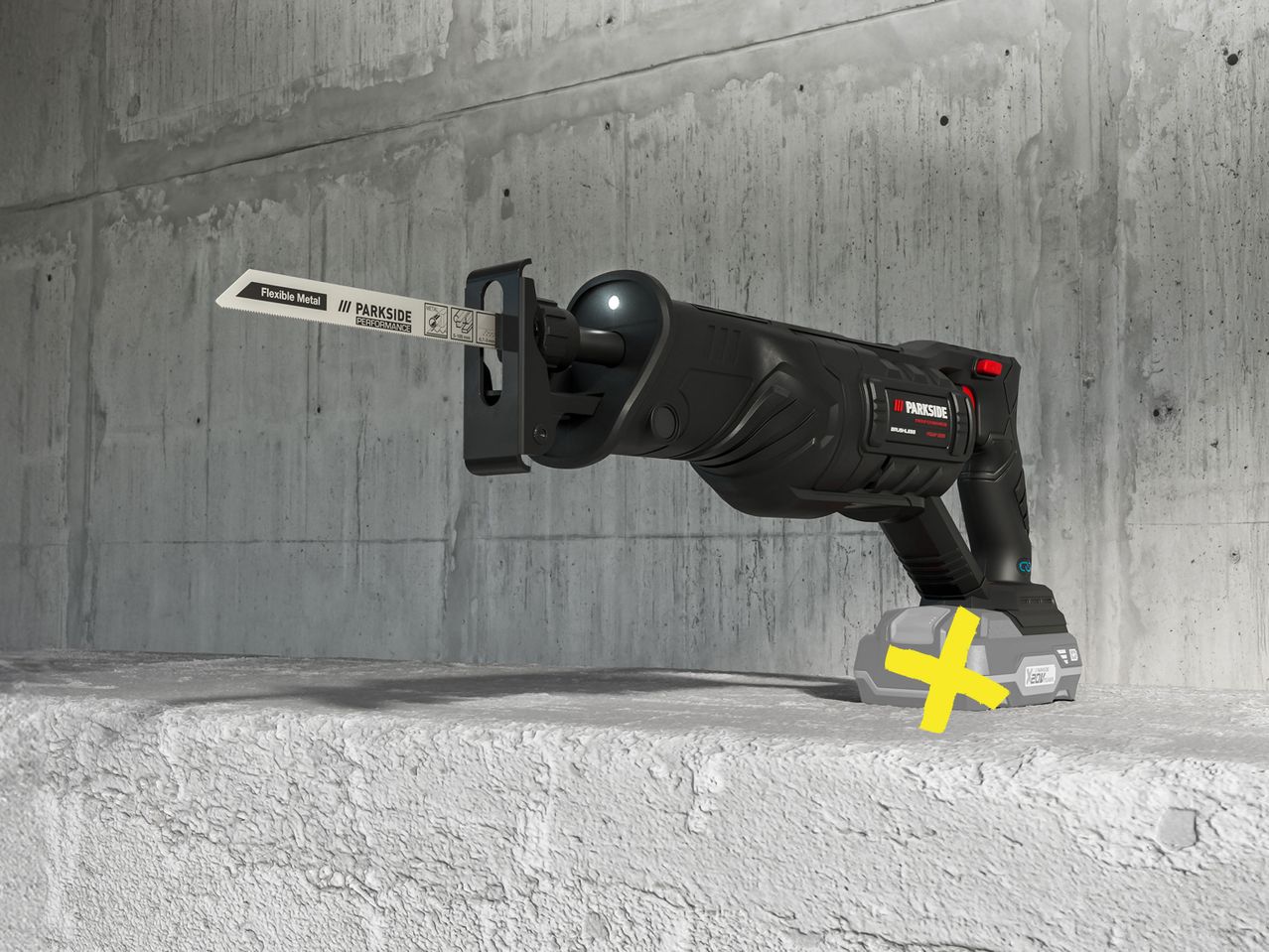 A Parkside Performance cordless sabre saw with a metal blade rests on a concrete surface.