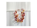 Autumn garland with leaves, pumpkins, and pinecones draped over a white shelf.