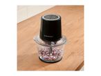 Food chopper with diced red onions on a wooden kitchen counter.