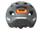 Сива велосипедна каска с червена задна светлина и светлоотразителни елементи.