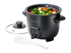 Black rice cooker filled with mixed vegetables, with a glass lid and serving spoon beside it.