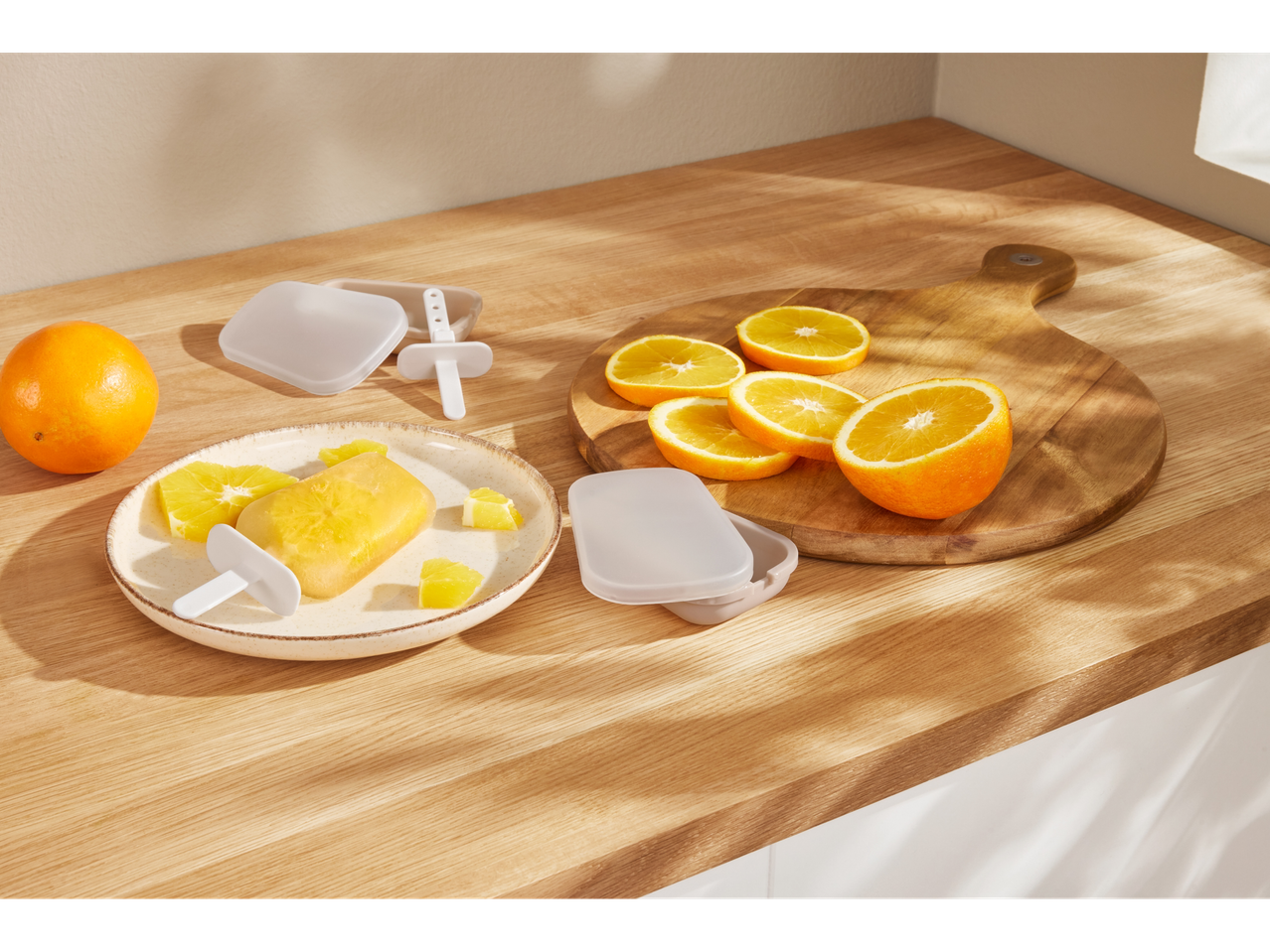 Homemade orange popsicles in silicone molds and wooden cutting boards.