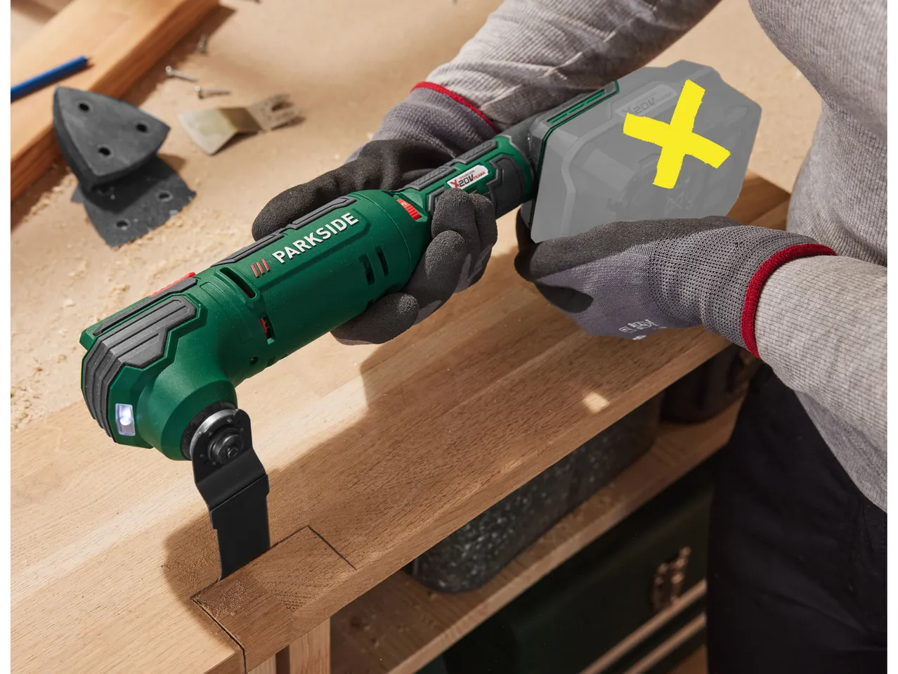 A person uses a Parkside multi-tool to carve wood.