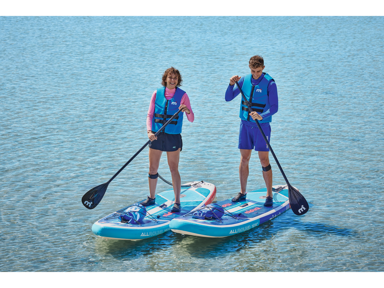 Du žmonės irklasuoja ant Aqua-Marina Allround 10'6 SUP lentų.