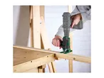 A person using a drill attachment to cut a piece of wood on a workbench.