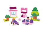 A colorful building block set featuring a house, tree, and two figures with vehicles.