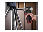A person using a cordless impact driver to fasten something on a metal stand.