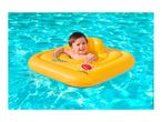 Happy baby in a yellow inflatable swimming ring in a bright blue pool.