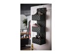 Black woven over-the-door organizer with three baskets holding toiletries and towels.