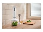 Hand blender set with chopper attachment, beaker, and ingredients on a kitchen counter