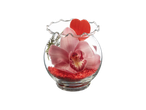 Pink orchid in a glass bowl with red decorative stones and a red heart.
