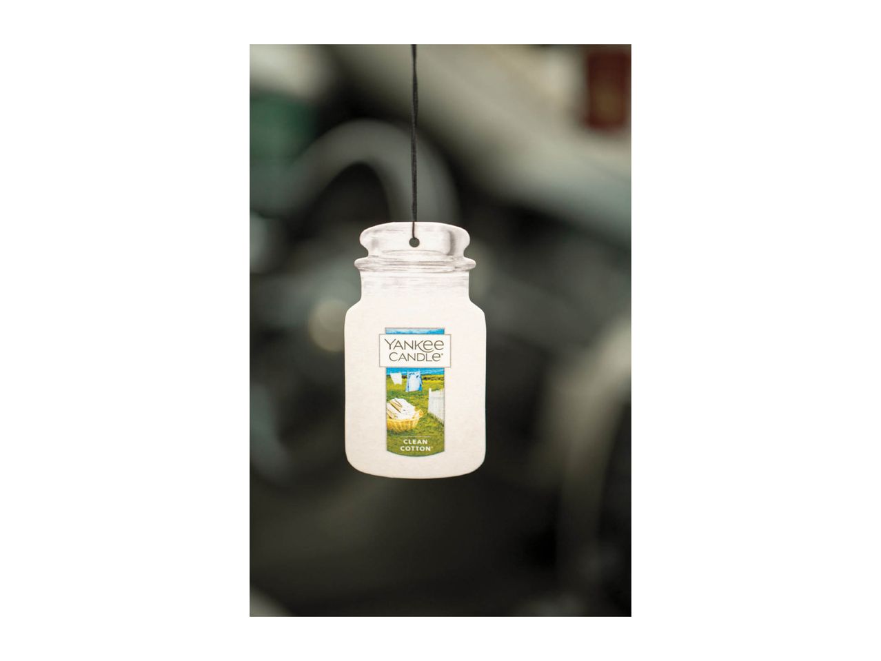 Air freshener shaped like a jar, with a label showing laundry on a clothesline.