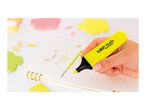 Hand highlighting text in a notebook with a yellow marker, surrounded by colorful office supplies.