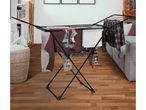 A black clothes drying rack with various garments hanging on it in a living room.