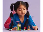 A young girl playing with LEGO Friends lifeguard and jet ski sets.