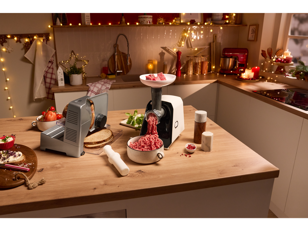 Electric slicer and meat grinder in a festively decorated kitchen.