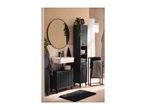 Modern bathroom with black furniture, white sink, round mirror, and patterned towels.
