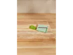 Kiwi slicer and kiwi slices on a wooden cutting board.