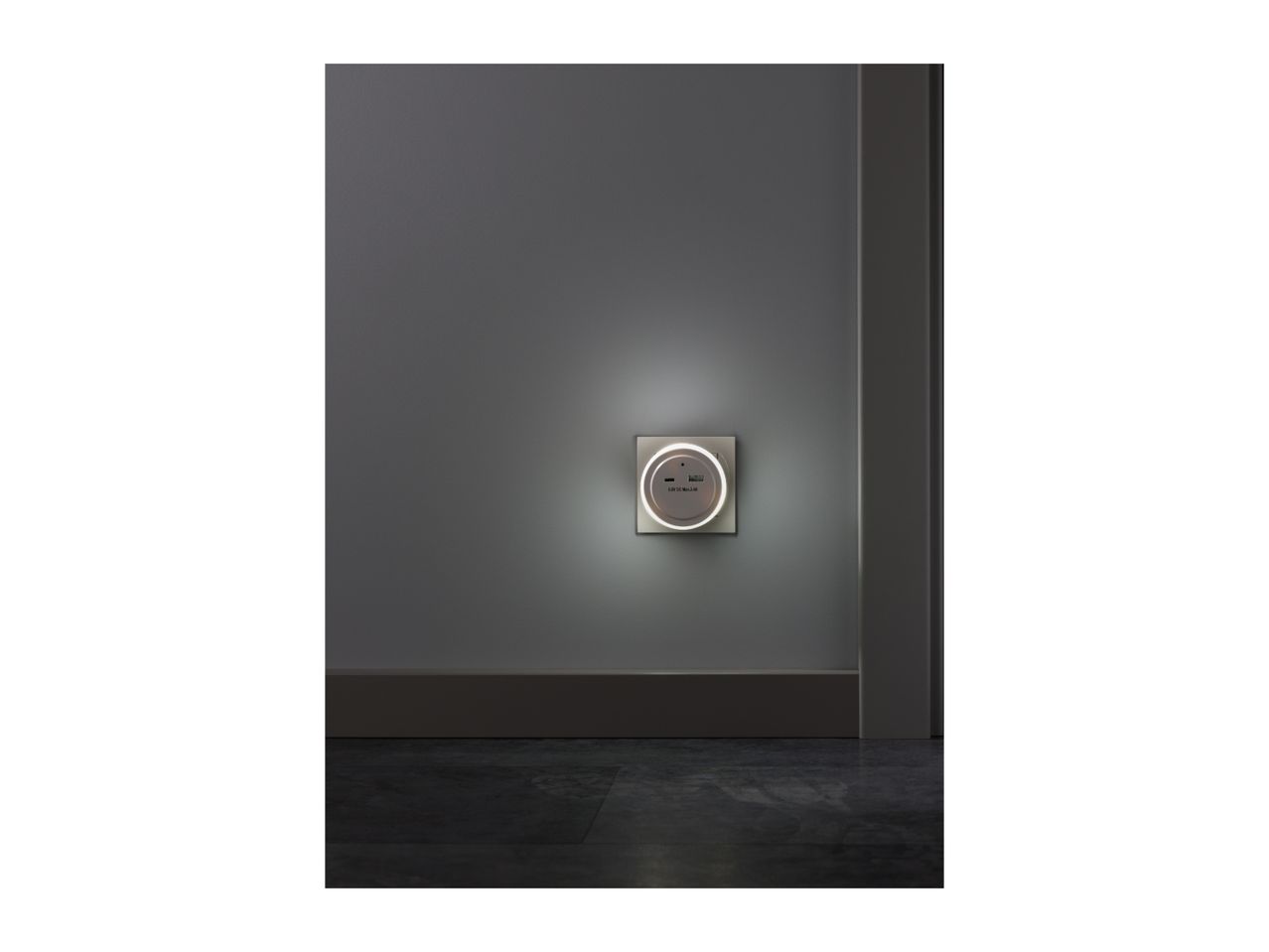 A wall-mounted USB charging outlet with an illuminated ring in a modern room.