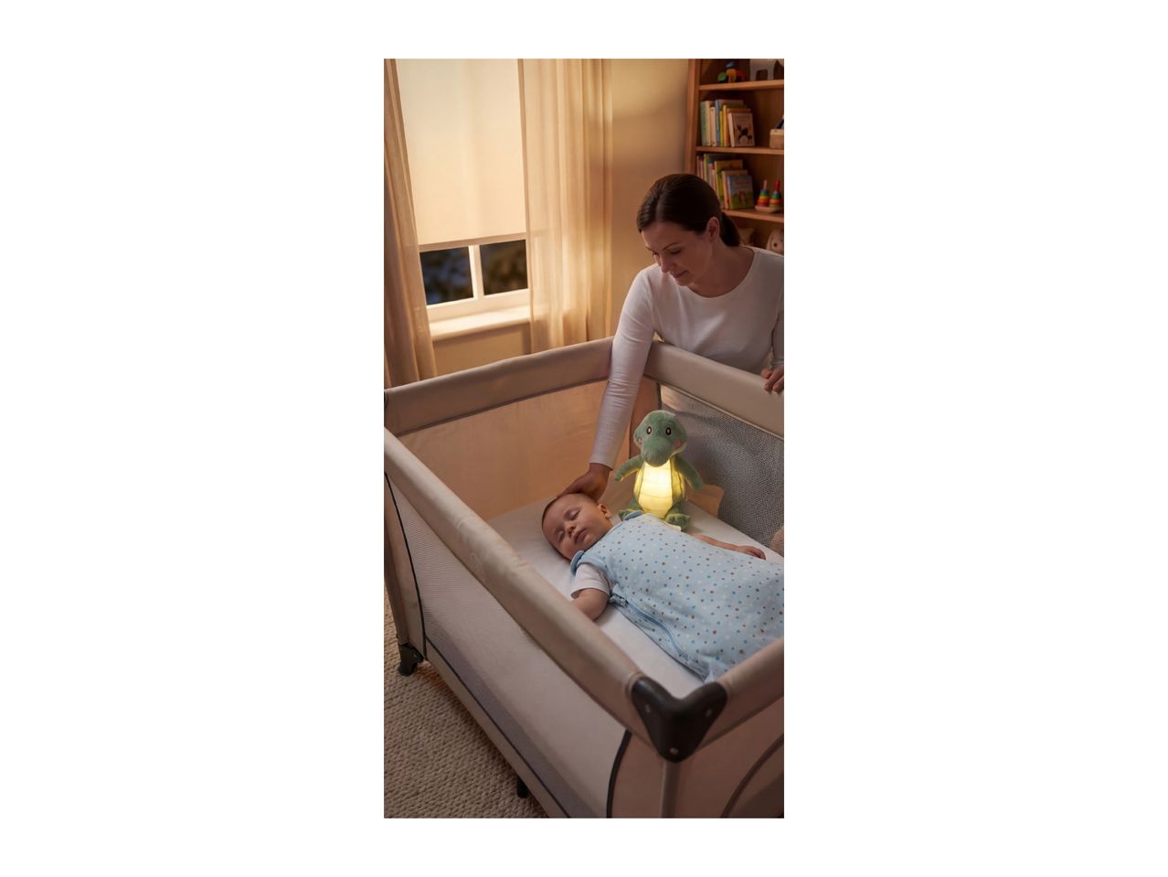 A mother gently touches her baby sleeping in a travel cot, with a glowing dinosaur night light.