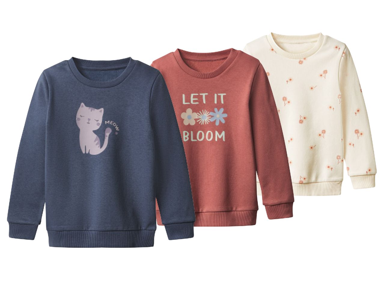 Tri dječje dukserice: plava s mačkom, crvena s natpisom 'LET IT BLOOM' i bež s cvjetnim uzorkom.