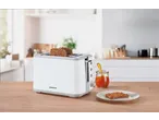 White Silvercrest toaster with toast and jam on a wooden table.