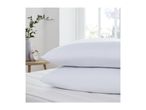 Two white pillows stacked on a mattress in a bright bedroom.
